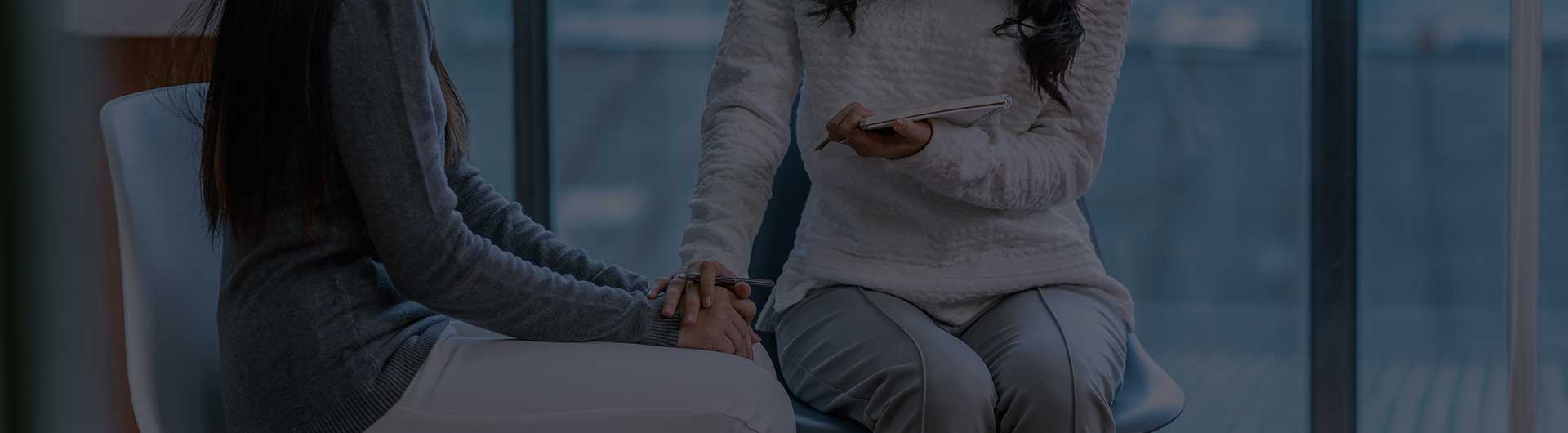 Psychiatrist giving advice to a patient in their clinic. Psychiatrist giving advice to a patient in their clinic.