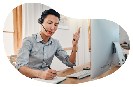 Virtual assistant taking a call from a customer while typing on a laptop.