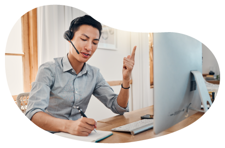 Virtual assistant taking a call from a customer while typing on a laptop. Virtual assistant taking a call from a customer while typing on a laptop.