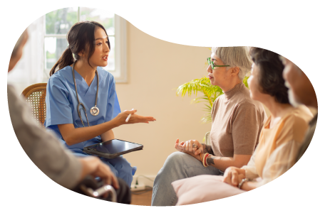 Senior care center employee speaking with residents. Senior care center employee speaking with residents.