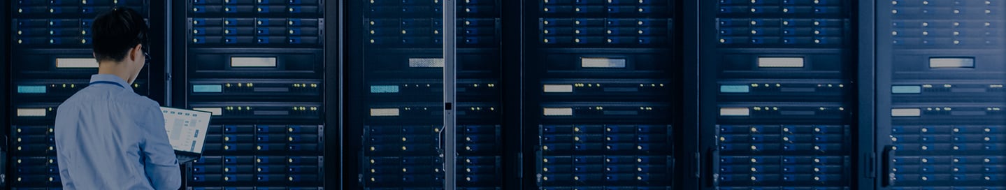 Tech professional reviewing machinery in a data center. Tech professional reviewing machinery in a data center.