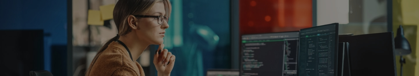 An employee for a managed service provider (MSP) working on several monitors.