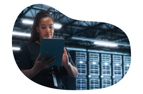 SaaS employee works on a tablet in a server room.