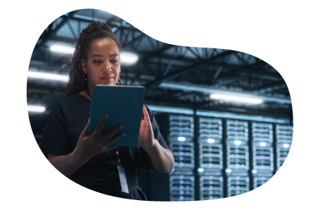 SaaS employee works on a tablet in a server room.