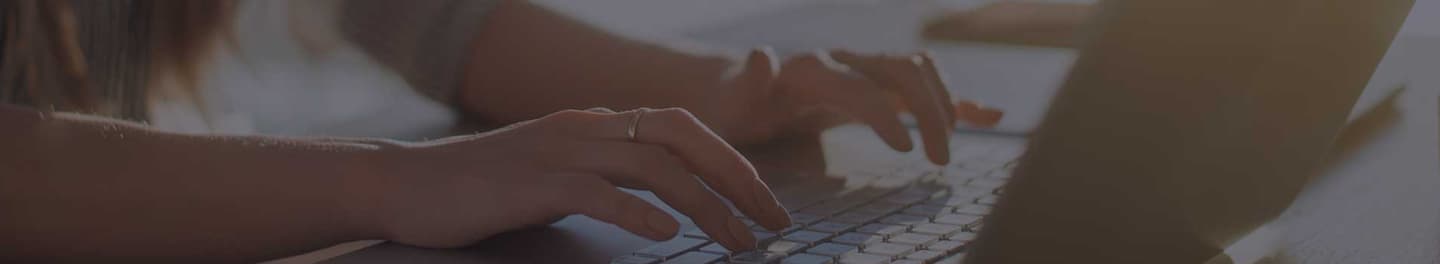 Technical writer at desk typing on a laptop. Technical writer at desk typing on a laptop.