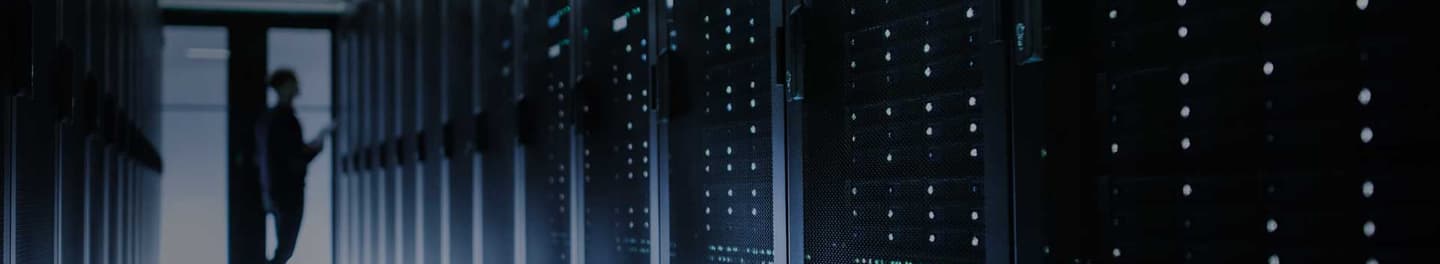 Long hallway of servers with a silhouette of a person at the end of the hallway.