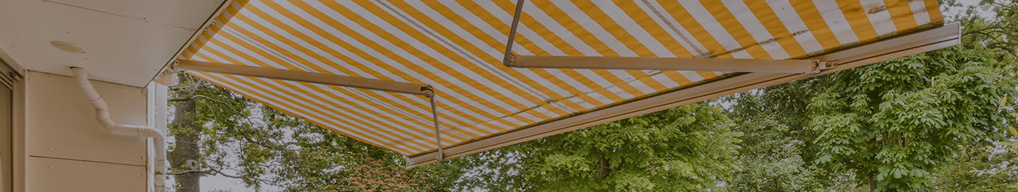 A striped awning in a backyard patio. A striped awning in a backyard patio.