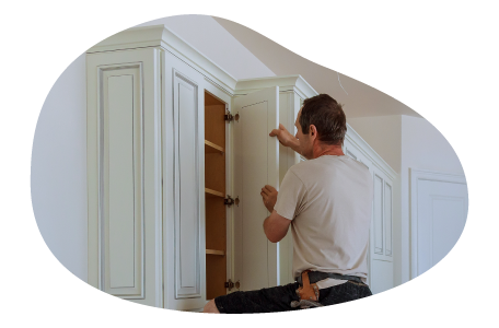 A contractor installing a kitchen cabinet. A contractor installing a kitchen cabinet.
