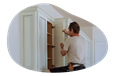 A contractor installing a kitchen cabinet.