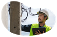 A cable installer working on a utility pole.