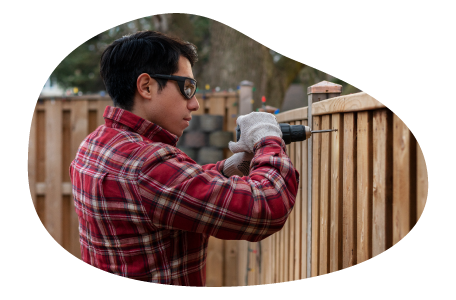 Contractor installing a fence in a yard. Contractor installing a fence in a yard.