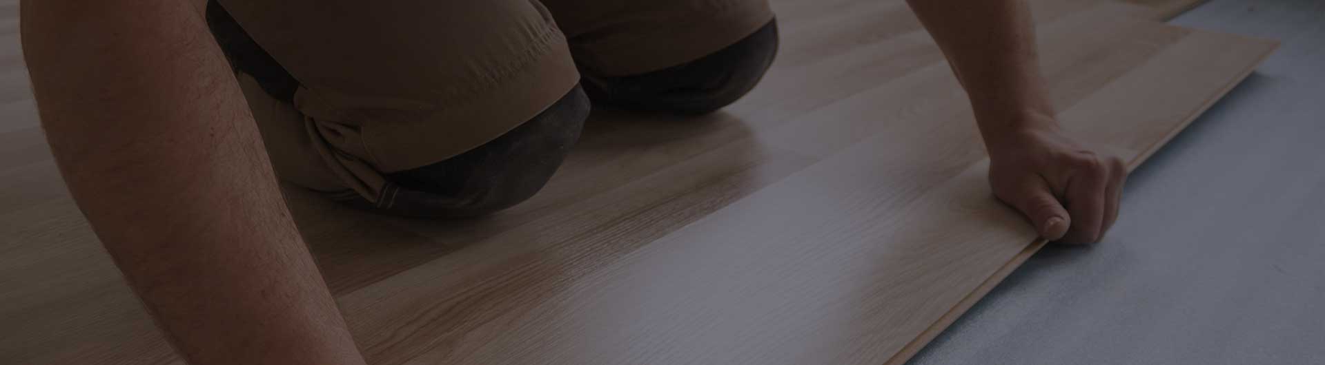 Person laying down flooring. Person laying down flooring.