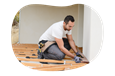 Contractor installing floorboards in a home.