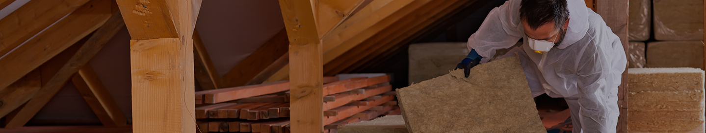 A contractor installs insulation in a client's home.