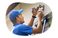 A contractor installs an exterior light over a garage.