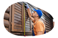 A contractor measuring the shutters on a log cabin.