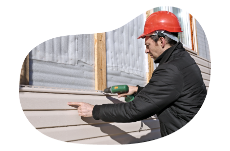 Contractor installing siding onto a house.