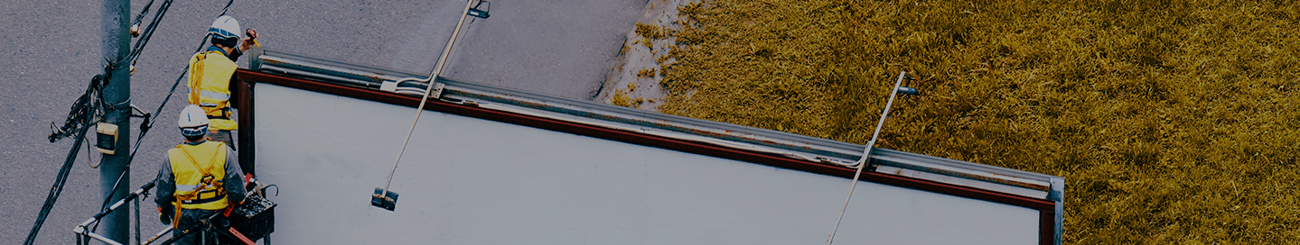 Sign installers putting up a billboard.