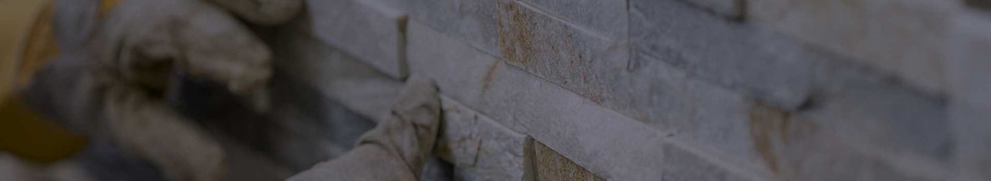 Installer holding up stone tiles.