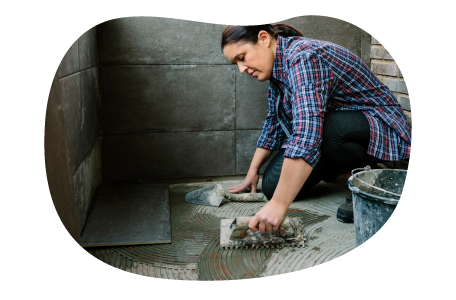 Contractor installing stone tiles in a building.