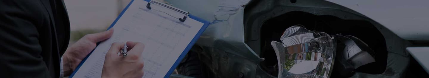 Claim adjustor assessing damage at a car crash.