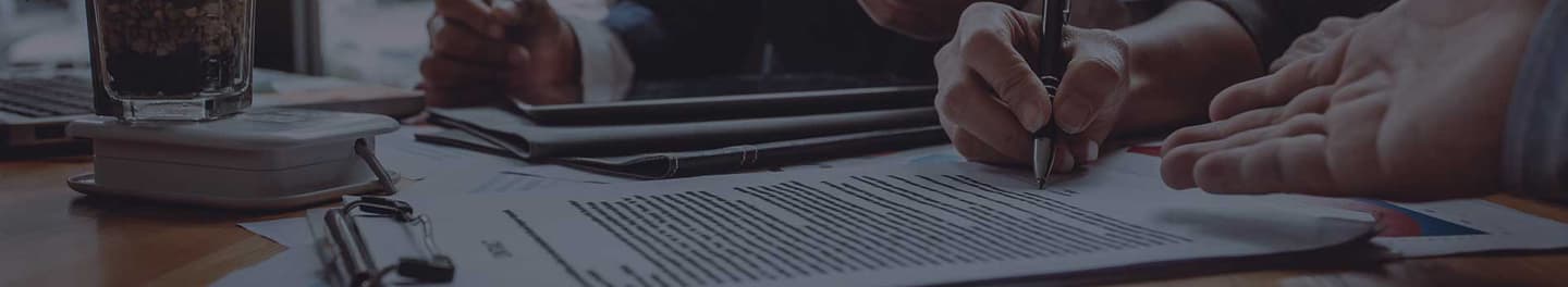 Client signing insurance paperwork at desk.