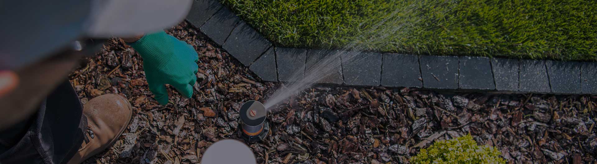 Irrigation specialist in a yard testing a sprinkler.