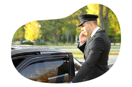 A chauffeur talks on the phone while getting into their limo. A chauffeur talks on the phone while getting into their limo.
