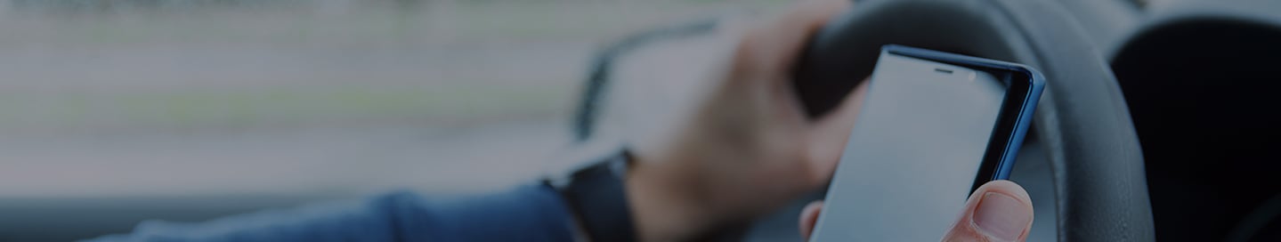 A driver checks their rideshare app to find a passenger.