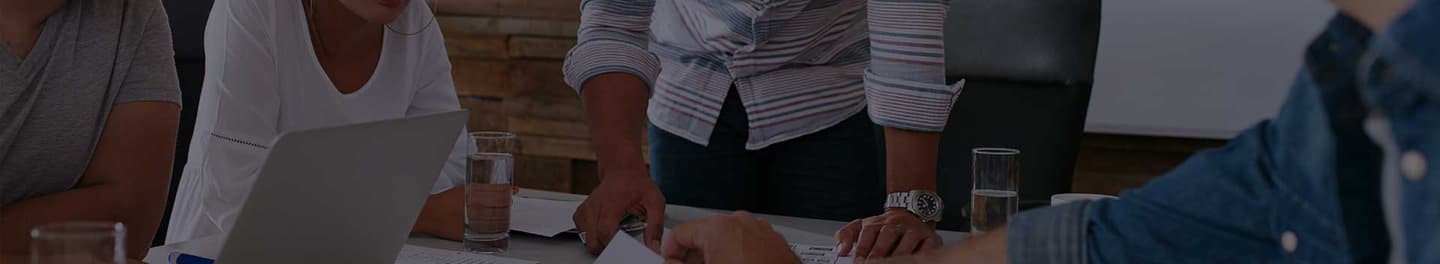 Individuals gathered around a desk discussing ideas for a campaign.