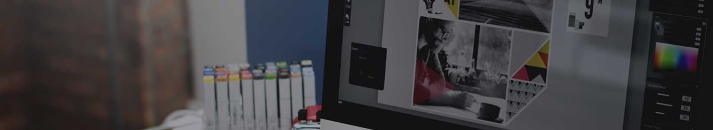 Graphic designers working on design displayed on a monitor.