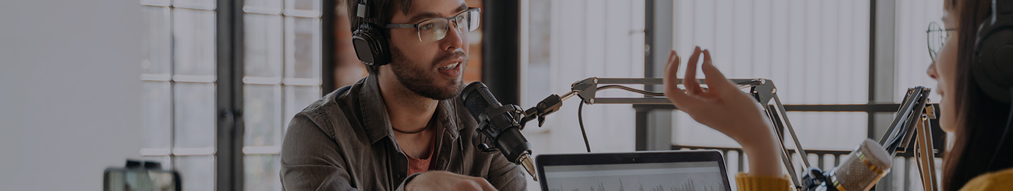 A podcaster interviewing a guest in their studio.
