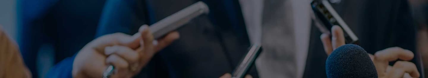 An individual and reporters at a press conference.