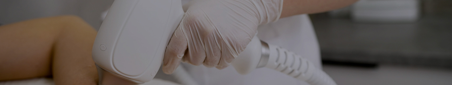 A hair removal specialist uses a laser treatment on a client.