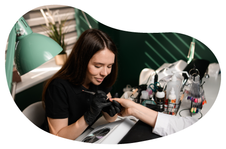 Nail technician working on a client's hand. Nail technician working on a client's hand.