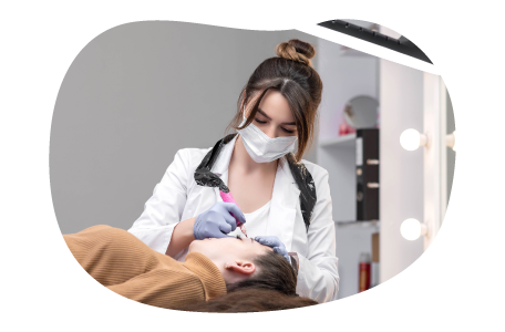 Permanent makeup artist applying makeup to a client's face. Permanent makeup artist applying makeup to a client's face.