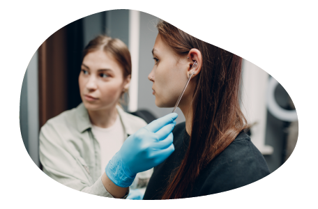 A body piercer prepares a client in a piercing shop.