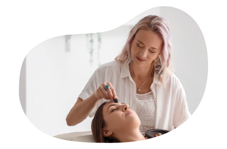 A Reiki practitioner places a healing stone on a client's forehead. A Reiki practitioner places a healing stone on a client's forehead.