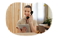 A receptionist at a sauna talks to a client on the phone.