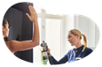 A technician gives an airbrush tan to a client at a tanning salon.