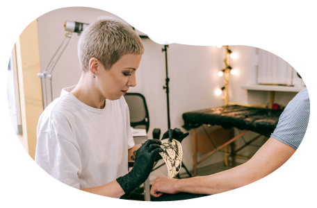 A gloved tattoo artist places a stencil on a client's arm. A gloved tattoo artist places a stencil on a client's arm.
