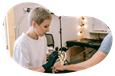 A gloved tattoo artist places a stencil on a client's arm.