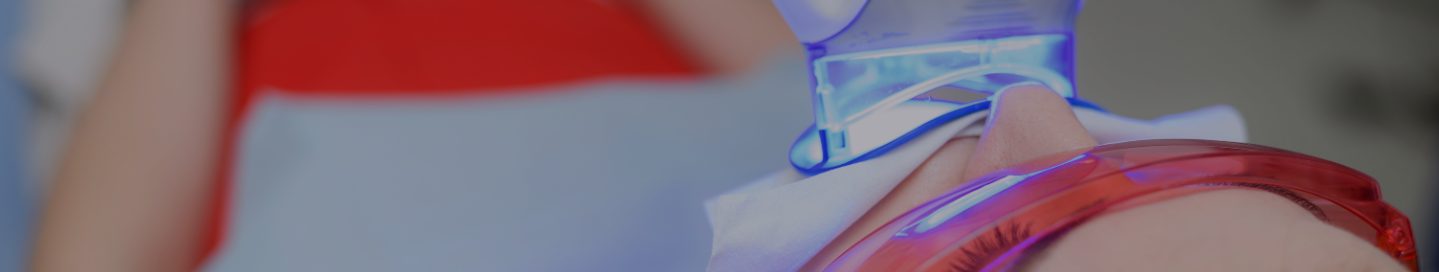A client undergoes a teeth whitening treatment at a dentist's office.