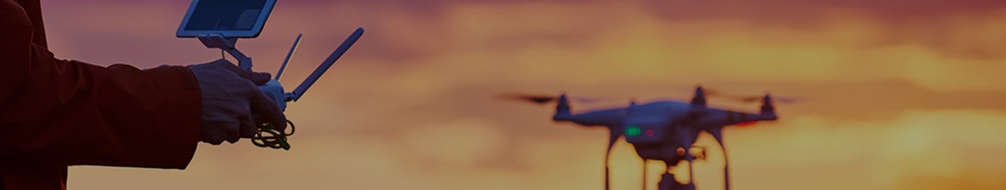 A pilot flying a drone at sunset. A pilot flying a drone at sunset.