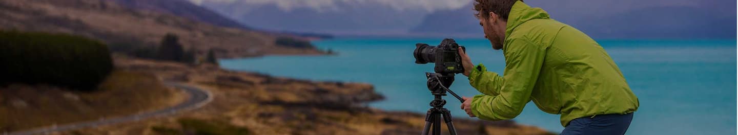 Photographer capturing a scene by the sea.