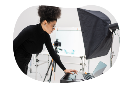 Photographer reviewing photos on a laptop in a studio.