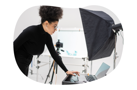 Photographer reviewing photos on a laptop in a studio. Photographer reviewing photos on a laptop in a studio.