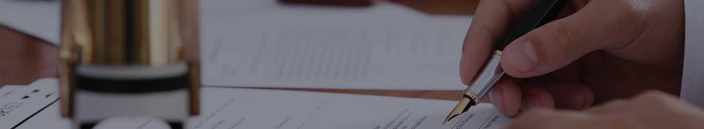 Notary signing paperwork at a desk.