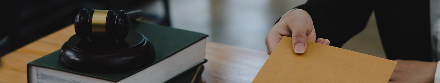A process server delivering a document across a desk.