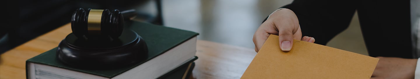 A process server delivering a document across a desk. A process server delivering a document across a desk.